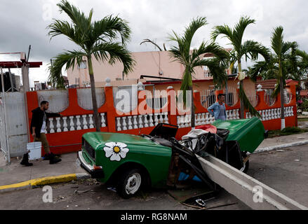 Havanna, Kuba. 28 Jan, 2019. Kubaner Spaziergang in Guanabacoa neben einem Auto zerstört Nach einem Tornado Verwüstung angerichtet hat. Einen heftigen Tornado zu Kuba am Sonntag Abend (Ortszeit) 27.01.2019 Kosten mindestens drei Menschen ums Leben. Weitere 172 Menschen wurden verletzt, sagte Präsident Miguel Díaz-Canel auf Twitter. Den Stadtteil Regla in der Hauptstadt Havanna besonders hart getroffen wurde. Credit: Eliana Aponte/dpa/Alamy leben Nachrichten Stockfoto