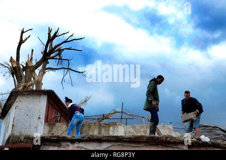Peking, Kuba. 28 Jan, 2019. Menschen sauber bis eine beschädigte Haus in der Tornado - betroffenen Bereich in der Gemeinde Regla in Havanna, Kuba, Jan. 28, 2019. Einem leistungsfähigen Tornado durch die kubanische Hauptstadt auf Sonntag Nacht, wobei drei Menschen getötet und 172 weitere verletzt. Credit: Joaquin Hernandez/Xinhua/Alamy leben Nachrichten Stockfoto