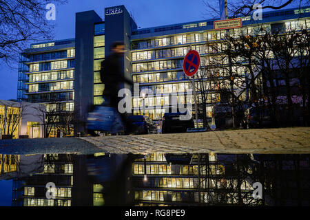 Heidelberg, Deutschland. 28 Jan, 2019. Ein Passant geht das Hauptgebäude des Deutschen Krebsforschungszentrums (DKFZ), deren Bau in einer Pfütze von Regen reflektiert wird. Heute, nur sehr wenige Krebspatienten sterben aus einem primären Tumor, sondern aus seiner Metastasen - Forscher aus Heidelberg, dies zu stoppen. (Dpa Nachrichten: "gegen Metastasen - Heidelberger Krebsforscher sieht Chancen' von 29.01 Kämpfen. 19) Credit: Uwe Anspach/dpa/Alamy leben Nachrichten Stockfoto