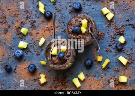 Schokolade Avocado Mousse auf einem Schiefer Hintergrund.