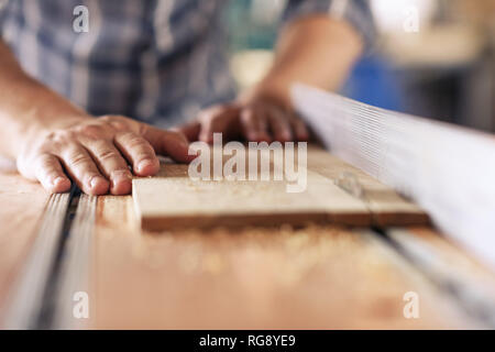 Woodworker sägen Bretter, in seiner Schreinerei Stockfoto