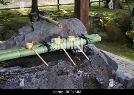 Japan Kultur - Reinigung der Brunnen mit hölzernen Löffel in einem buddhistischen Tempel (Besichtigen) in Kyoto. Stockfoto