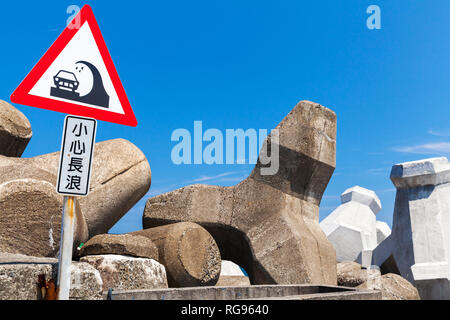 Achtung große Wellen. Chinesische Schild auf wellenbrecher montiert. Text Label bedeutet: Vorsicht mit langen Wellen. Stockfoto