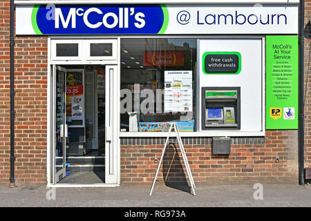 McColls-24-Stunden-Geschäft und Zeitungskiosk, Vorderfenster mit PayPoint und kostenlosem geldautomaten in der Wand im Dorf Lambourn Berkshire, Großbritannien Stockfoto