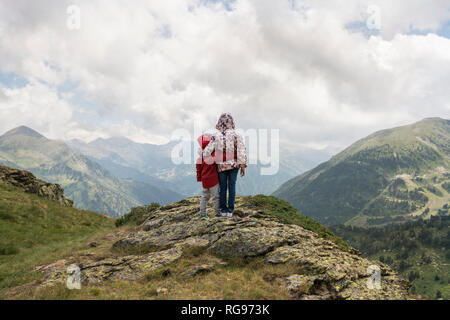 Andorra, Ordino, junges Mädchen und ihr Bruder, um den Arm, stehend auf Sicht in die Berge Stockfoto