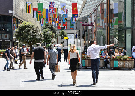 Käufer wandern Westfield Stratford London outdoor Shopping Center Mall Mann Zeigefinger international World Flags Newham East London England Großbritannien Stockfoto