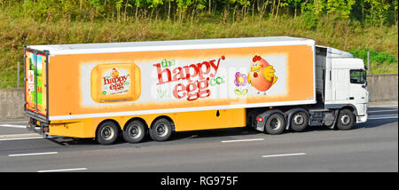 Seitenansicht eines weißen Lkw supply chain Juggernaut Lkw Lkw & artikuliert trailer Werbung Happy Ei Food Company Business Logo auf der Autobahn m25 IM VEREINIGTEN KÖNIGREICH Stockfoto