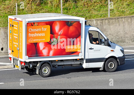 Auf der Suche nach Seiten- und Rückansicht Sainsburys Supermarkt home Food Delivery van & Fahrer mit Fahrzeug Werbung frische Tomaten fahren Auf de Autobahn Stockfoto