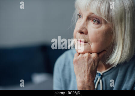 Portrait von nachdenklich Senior Frau propping Kinn mit der Hand zu Hause Stockfoto