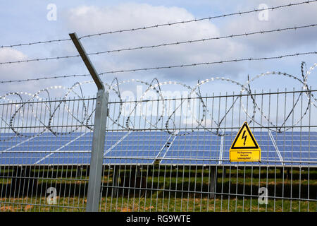 Wegweiser und Zaun in einem Open Space Solar Photovoltaik Anlage, Deutschland, Europa Stockfoto