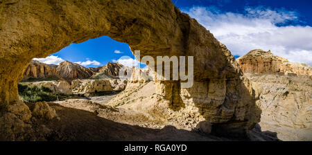 Panoramablick über einen Felsbogen in die karge Landschaft des Oberen Mustang Stockfoto
