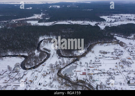 Drone Ansicht von Winter Forest und geschwungene Fluß während Bewölkter Tag Stockfoto