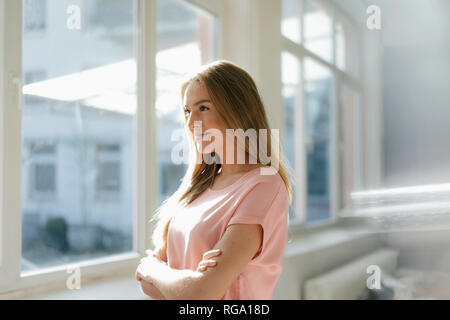 Portrait von lächelnden jungen Frau in ihrem Loft Stockfoto