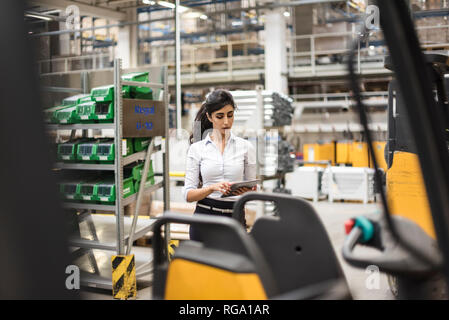 Frau mit Tablette im Factory Shop Boden Stockfoto