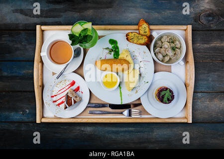 Mittagsmenü. Knödel, Hühnerschnitzel mit Kartoffelpüree und russische Heringssalat, serviert mit dem Besteck. Stockfoto