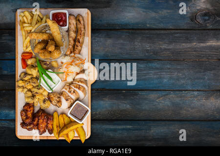 Bier Snacks. Chicken Snacks serviert auf Schneidebrett mit dem Hintergrund. Ansicht von oben. Stockfoto