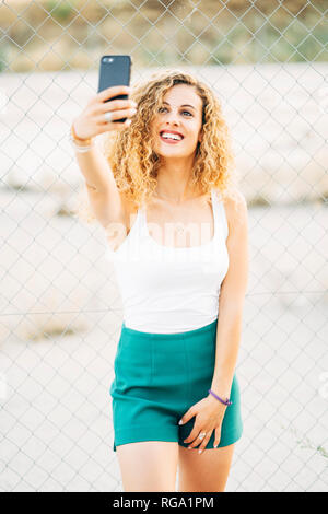 Porträt der blonde junge Frau unter selfie mit Handy Stockfoto