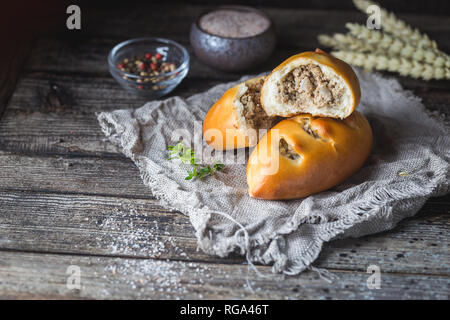 Traditionelle russische Mini Pasteten auf rustikalen Holzmöbeln Hintergrund. Stockfoto