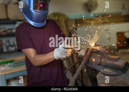 Handwerkerin Schweißen von Metall in ihrem Workshop Stockfoto