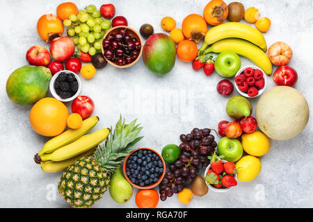 Herz aus gesunden bunten Früchten, Pflaumen Erdbeeren Himbeeren Orangen, Äpfel, Kiwis, Weintrauben, Heidelbeeren mango Kaki Ananas auf die Weiße Stockfoto