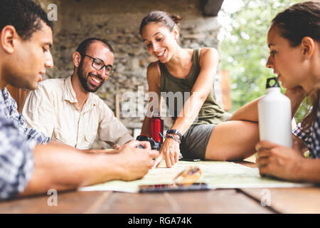 Gruppe der Wanderer sitzen gemeinsam wandern Route auf Karte suchen Stockfoto