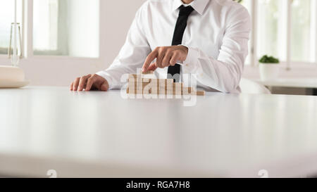 Unternehmen Vision Concept - Geschäftsmann sitzt in seinem Büro Schreibtisch Gebäude Schritte der holzpflöcke. Stockfoto