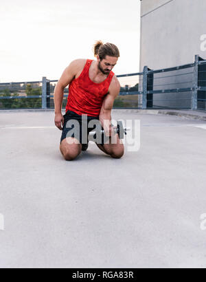 Junger Mann mit Hantel Stockfoto