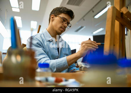 Schüler Malen auf staffelei im Kunstunterricht Stockfoto