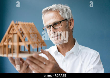 Erfolgreiche Architekt bei Modell eines Hauses suchen Stockfoto