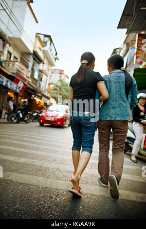 Freunde gehen Arm in Arm auf eine vietnamesische Straße. Stockfoto