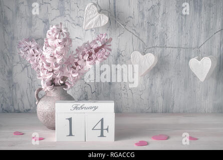 Valentines Tag noch Leben mit Holz- Kalender, rosa Hyazinthe Blumen und girlande Lichter in Form von Papier Herzen auf rustikalen Hintergrund Stockfoto