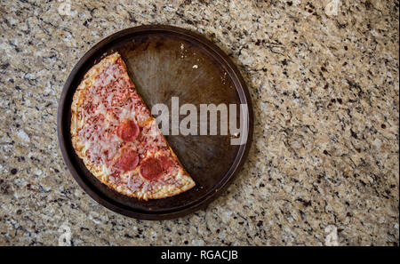 Die Hälfte der übrig gebliebenen gefrorene Pizza auf dem Zähler nach oben verworfen. Stockfoto