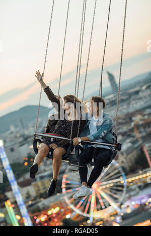 Junges Paar in Liebe, Reiten auf einem Rummelplatz chairoplane Stockfoto