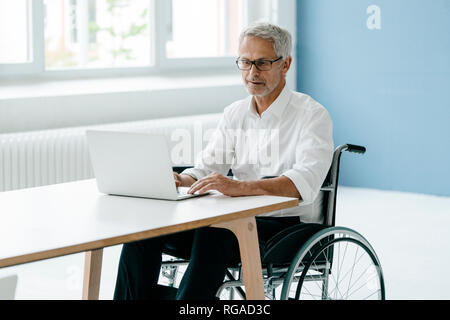 Behinderte Manager in einem Rollstuhl, Arbeiten im Büro Stockfoto