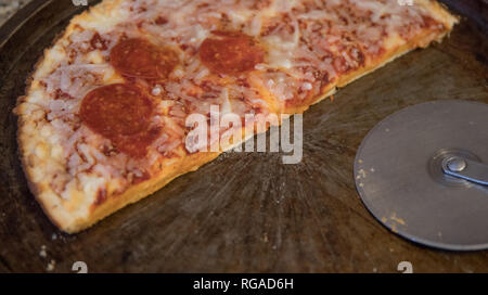 Die Hälfte der übrig gebliebenen gefrorene Pizza auf dem Zähler nach oben verworfen. Stockfoto