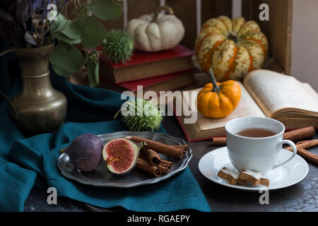 Herbstliche Stillleben mit Feigen, Zimtstangen, Bücher und einer Tasse Kaffee Stockfoto