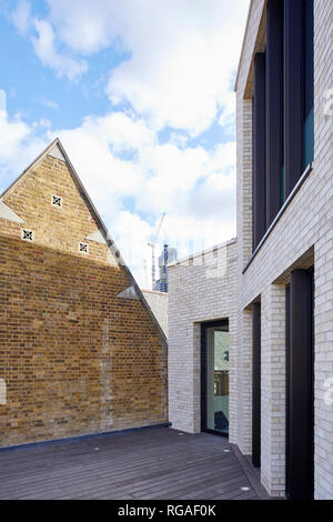 Gegenüberstellung von historischen Kirche und neue Fassade auf der Dachterrasse. Paul Street, London, Vereinigtes Königreich. Architekt: Steif+Trevillion Architekten, 201 Stockfoto