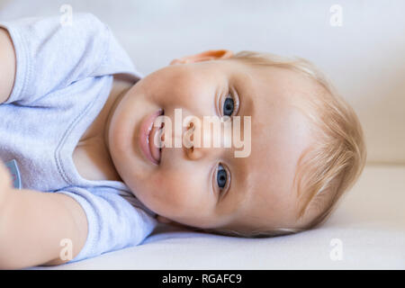 Portrait von blond Baby Mädchen liegt auf der Couch Stockfoto