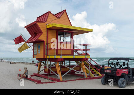 Eine Frau sitzt eine Pause von der 24. Straße lifeguard Tower am Strand von Miami, Florida, USA zu nehmen Stockfoto