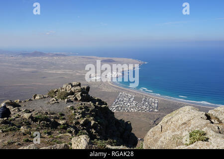 Blick vom Mirador de Ermita de las Nieves in die Playa de Famara eine Bungalow-Siedlung und Dit La Caleta, Riscos de Famara, Lanzarote, Stockfoto