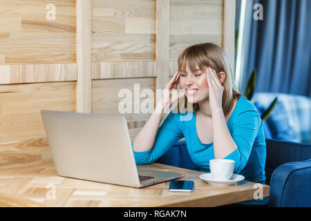 Warten, eine Idee! Seitenansicht Portrait von nachdenklich attraktive junge Mädchen Freelancer in blauen T-Shirt sitzen im Cafe und Arbeiten am Laptop, schließen Stockfoto