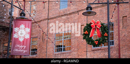 A Christmas wreath Dekoration hängen an einer Laterne im urbanen Raum. Stockfoto