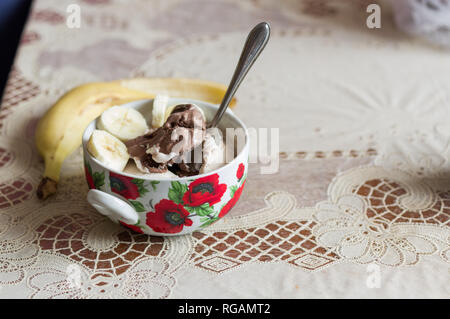 Schokolade Eis in eine Schüssel geben. Eis und Banane. Eis auf dem Tisch. Stockfoto