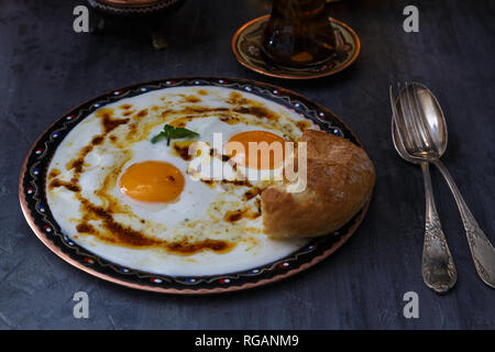 Cilbir, Eier, Butter und Joghurt mit würziger Kräuter, serviert mit Brot und Tee, türkische Küche, kopieren Raum Stockfoto