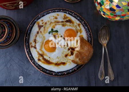 Cilbir, Eier, Butter und Joghurt mit würziger Kräuter, serviert mit Brot und Tee, türkische Küche, kopieren Raum Stockfoto