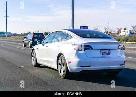 Januar 27, 2019 Santa Clara/CA/USA - Weiß Tesla Modell 3 Fahren auf der Autobahn in Silicon Valley, South San Francisco Bay Area. Stockfoto