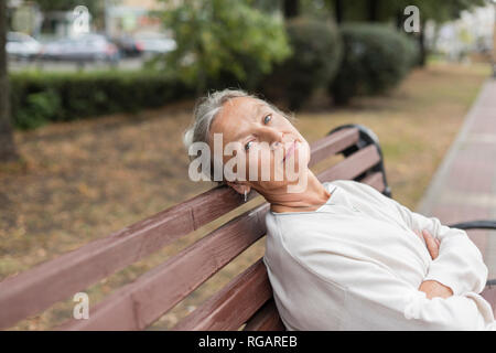 Portrait der älteren Frau entspannend auf einer Bank
