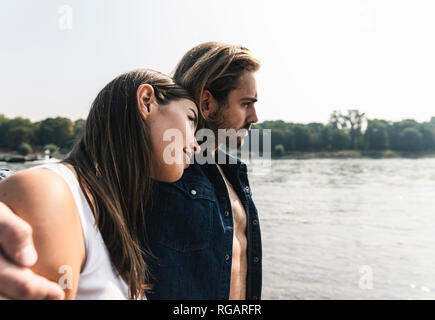 Junges Paar in Liebe am Flußufer Stockfoto