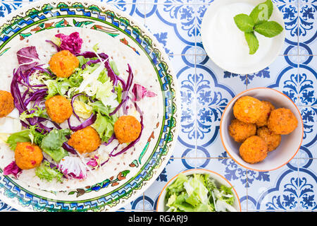 Falafel, Blattsalat, Rot- und Weißkohl und Joghurt Sauce mit Minze auf Wickeln Stockfoto