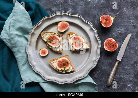 Gebutterte Scheiben Brot mit in Scheiben geschnittenen Feigen auf verzinnt Stockfoto